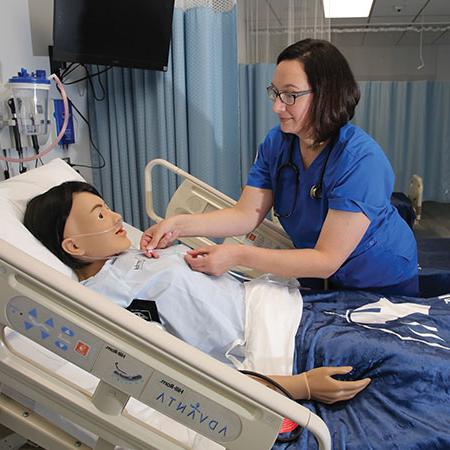 Immaculata大学 成人 和 专业 度 nursing student working with a mannequin
